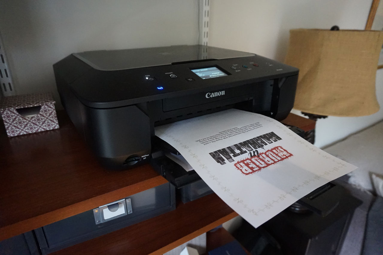 Downloadable murder mystery party kit being printed Printing downloadable mystery party kit. How to Host a Murder Mystery Party. #murdermysteryparty www.playingwithmurder.com